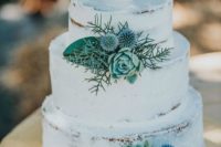 a naked wedding cake decorated with succulents, thistles and leaves for a rustic wedding