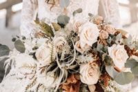 a neutral boho wedding bouquet of white and blush flowers, air plants, sucuclents, eucalyptus for a beach bride