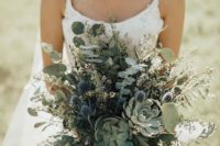 a neutral greenery wedding bouquet made of eucalyptus, succulents, thistles and some wildflowers for a summer boho bride