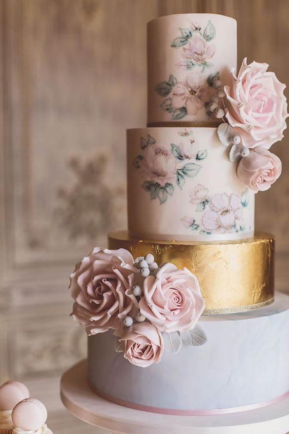a pastel wedding cake with blush floral patterns, a lilac and a gold leaf tier plus fresh and sugar blooms