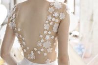 a pretty A-line wedding dress with a sheer bodice with floral appliques and a plain skirt with pockets and a low back is very chic