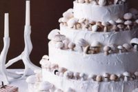 a pure white wedding cake topped with sugar mushrooms is a gorgeous woodland wedding idea