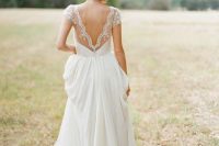 a refined A-line wedding gown with a lace bodice, a low back with cap sleeves and a pleated plain skirt with a train