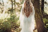 a refined lace A-line wedding dress with a low back, long sleeves, a capelet and a train for a forest nymph is very beautiful