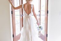 a romantic lace A-line wedding dress with a low back and a skirt with a train plus a bow on the back is a gorgeous vintage option