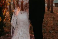 a romantic lace mermaid wedding dress with a cutout back, bell sleeves and a train for a summer woodland wedding