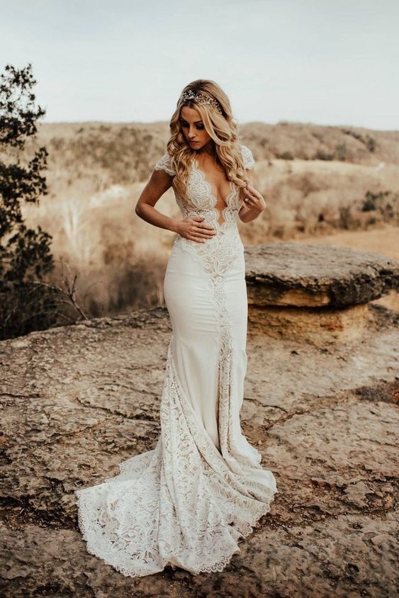a sexy fitting plain and lace wedding dress with a plunging neckline, cap sleeves and a train