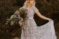 a sheath wedding dress with short sleeves and a high neckline plus gorgeous colorful florla embroidery and a bright floral crown