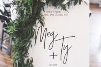 a stylish modern wedding sign with lots of textural greenery and neutral blooms can be DIYed
