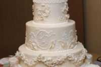 a tan wedding cake with floral patterns and lace plus fringe on top is a very refined idea