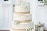a vintage rustic wedding cake with textural tiers, burlap ribbons and baby’s breath plus a chic topper