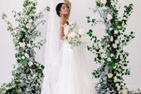 a wedding altar of greenery and white blooms is a chic statement decor idea