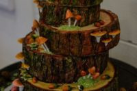 a whimsy wedding cake done as tree slices, with sugar acorns, mushrooms, moss and berries on top