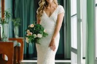 a white sequin V cut wedding dress with short sleeves and a small train is a chic and timeless idea