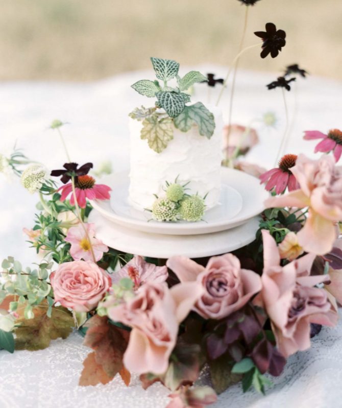 a white textural buttercream individual cake topped with greenery and thistles is a stylish idea