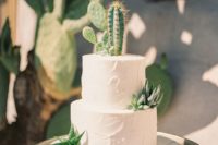 a white textural buttercream wedding cake topped with succulents and cacti for a rustic look