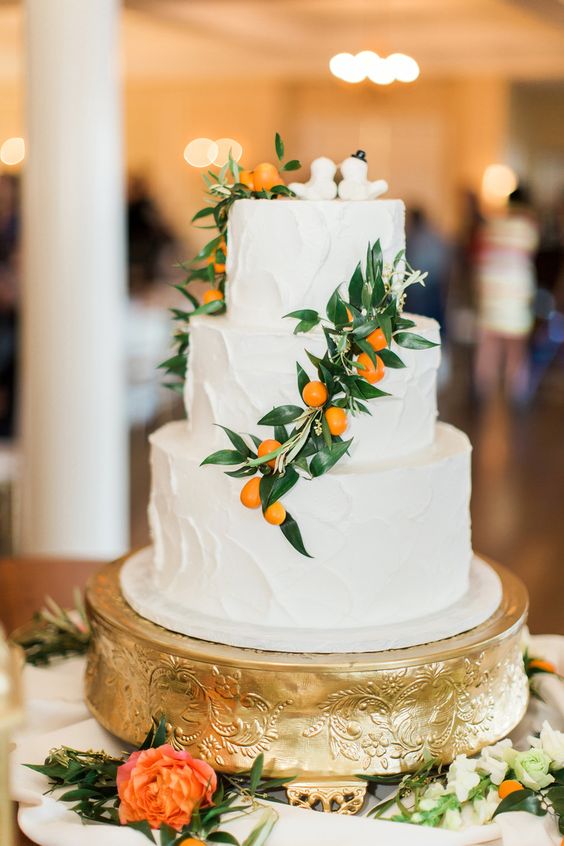 a white textural buttercream wedding cake with greenery and kumquats is an amazing idea for a summer wedding