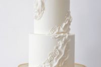 a white wedding cake with ruffles and beads is a very chic idea inspired by vintage designs