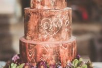 a woodland wedding cake imitating real wood, with fresh blooms, greenery and birdie toppers is super cute