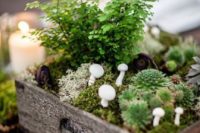 a woodland wedding centerpiece of a crate with moss, mushrooms, greenery and succulents