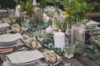a woodland wedding tablescape with fresh eucalyptus, greenery and billy balls in clear vases plus candles