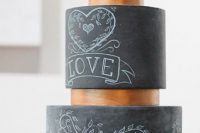 an elegant black chalkboard wedding cake with chalking and copper stands between the tiers is a lovely idea for a modern wedding