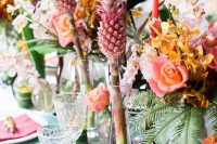colorful tropical wedding table decor with bold blooms, greenery and pink pineapples, fuchsia napkins and green chargers