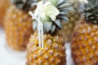 drinkable pineapples with straws are a lovely refreshing idea for a tropical wedding