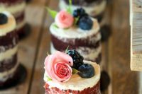 individual naked wedding cakes with a bit of buttercream on top, blueberries, blackberries and roses