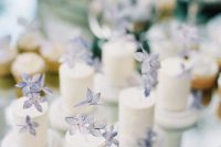individual white buttercream wedding cakes topped with blue sugar blooms for a spring or summer wedding