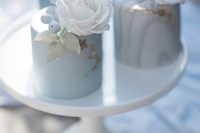 pastel blue individual wedding cakes topped with sugar berries, leaves and roses look very refined and chic