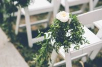 wedding aisle chairs decorated with greenery and white blooms are a chic idea