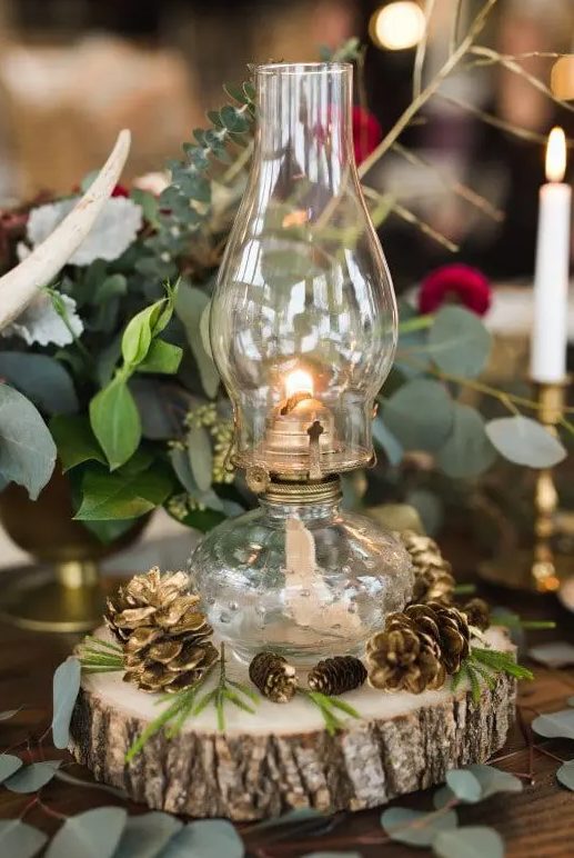 a Betty lamp placed on a wooden slice with gilded pinecones looks chic and simple
