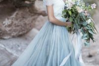 a beach wedding dress with a white lace bodice, a blue layered tulle skirt with a train looks spectacular