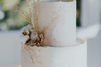 a glamorous wedding cake with golden leaves