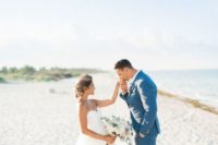 a bold blue groom’s suit paired with a white shirt and brown shoes for a blue beach wedding