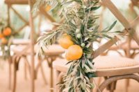 a chair decorated with olive branches with olives and lemons is a cool idea for a Mediterranean wedding