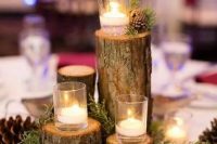 a classy woodland wedding centerpiece of tree stumps with floating candles, greenery and pinecones is a cozy solution for a winter or fall wedding