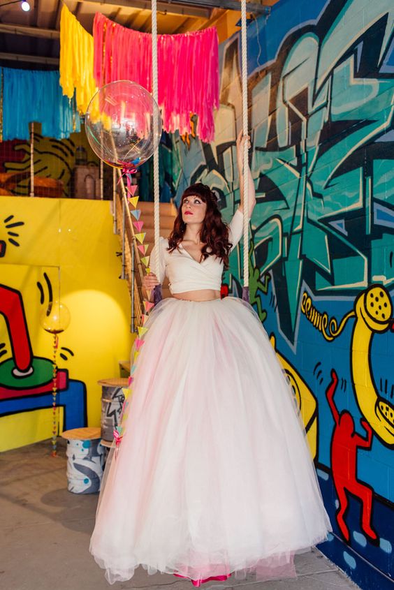 a colorful wedding space with bold graffiti on the walls, with colorful long fringe and a balloon with bright triangles is a lovely idea