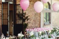 a cozy summer bridal shower table with white blooms and greenery, pink candles and balloons and cards is very cute