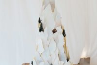 a creative shard wedding cake showing off a mountain with trees, deer and other animals