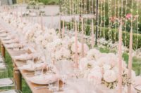 a cute and ethereal sumemr bridal shower table in blush and white, with blush candles, pastel blooms, linens and lots of lights