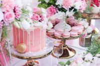 a delightful bridal shower dessert table with pink sweets, a drip pink cake, blooms, greenery looks wow
