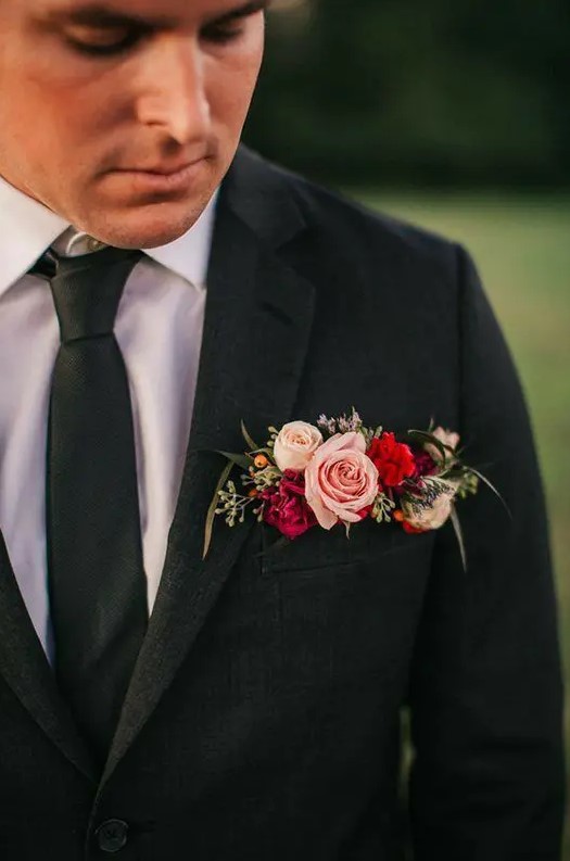 a graphite grey blazer with a colorful pocket square done with pink, hot pink and red blooms, berries and seeded euclayptus