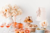 a peachy table with blooms, a blush cake, some citrus, wine and delicious sweets for a summer bridal shower