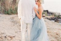 a strapless layered light blue wedding dress with a train for a bride at a blue beach or coastal wedding