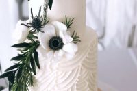a stylish white wedding cake with a textural tier, sugar and fresh blooms and greenery is very refined