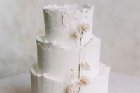 a subtle white textural wedding cake with a raw edge and dried blooms is a beautiful option for a spring wedding