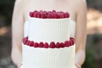 a textural white wedding cake topped with fresh raspberries is a delicious and lovely dessert idea for a wedding