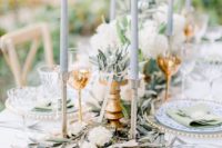 a wedding tablescape with olive branches, white blooms, grey candles is a very elegant and chic idea